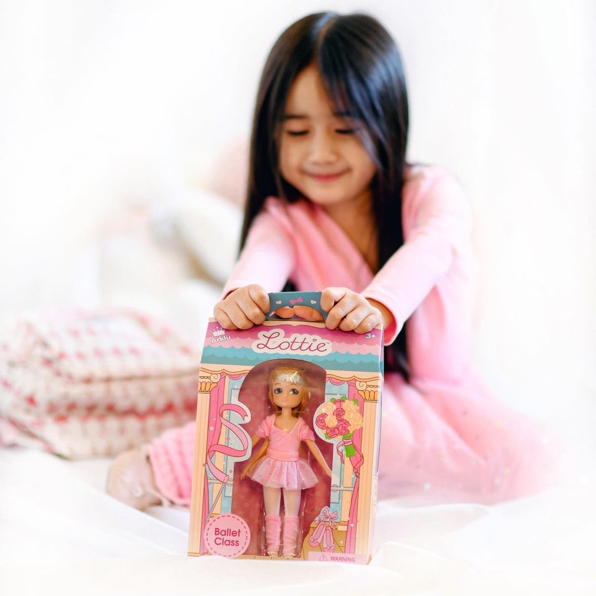 A girl unboxing her Ballet Class Lottie doll