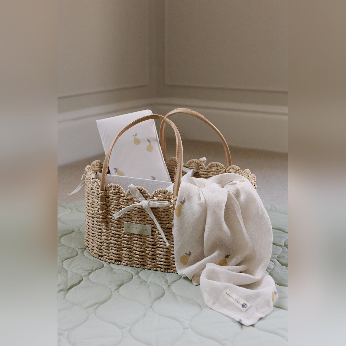 Scallop edge nappy caddy with a muslin on a soft nursery play mat