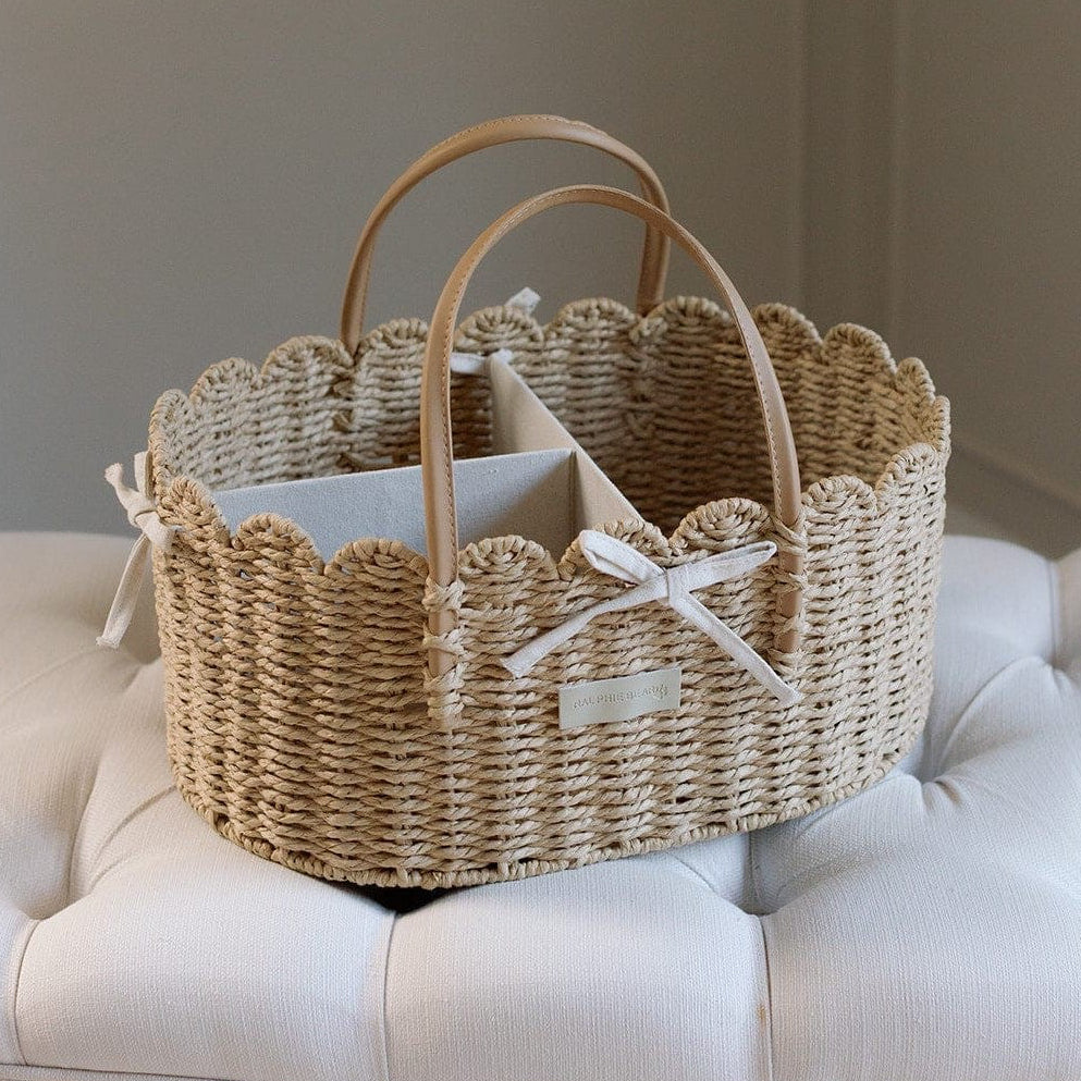 Woven scallop edge nappy caddy basket on a tufted nursery footstool