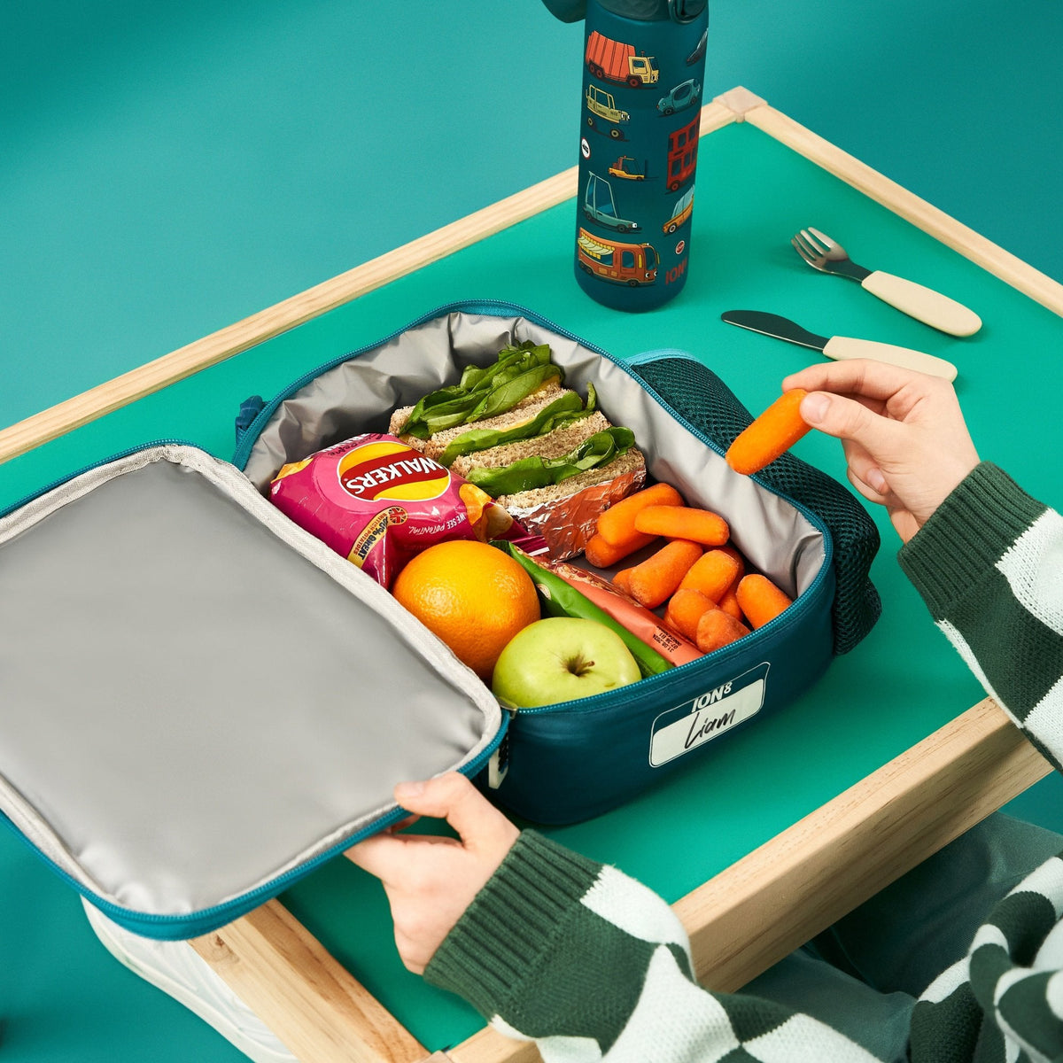 ION8 Automobiles lunch bag and bottle set in use, packed with a healthy lunch