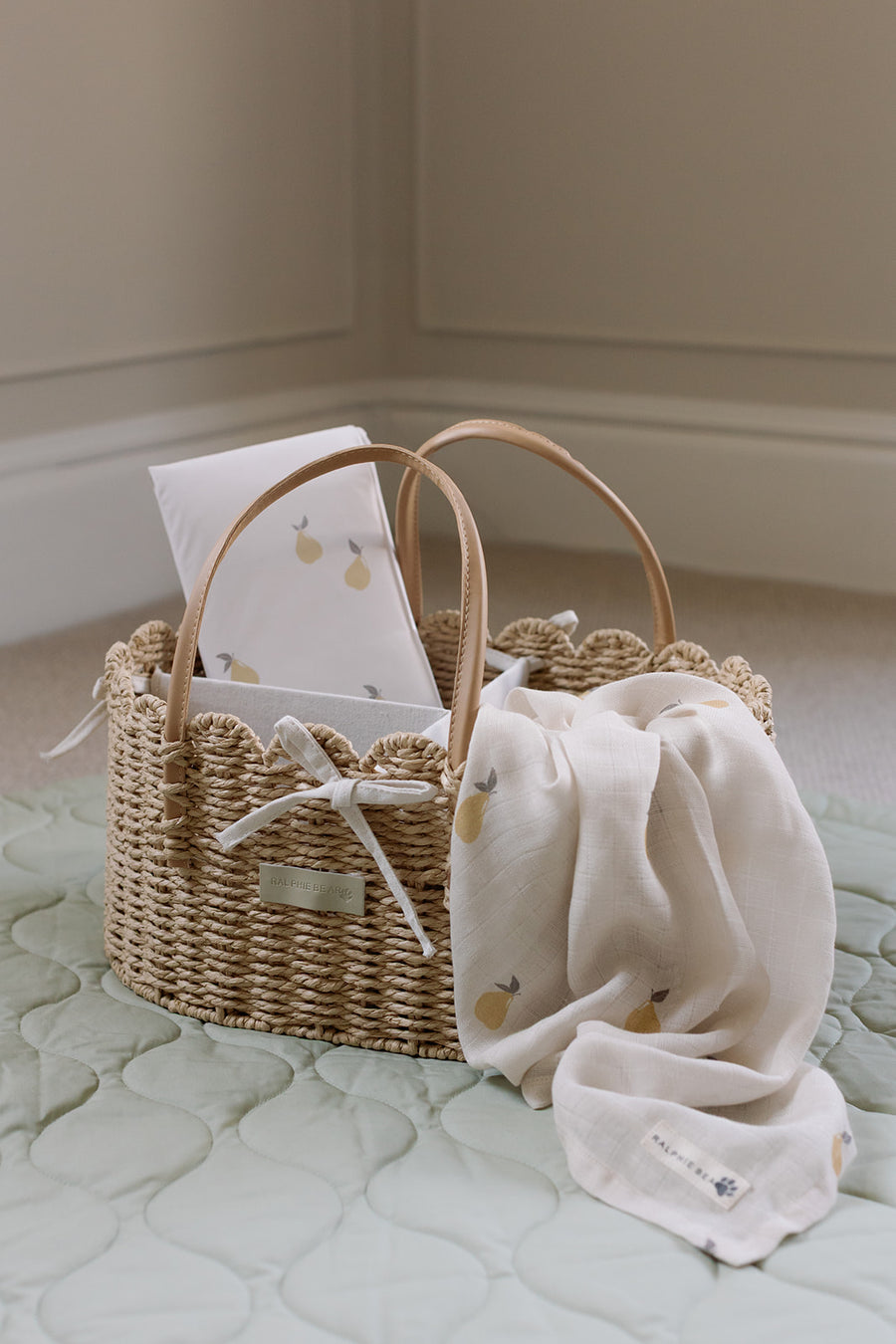 Woven nappy caddy with pear print muslin on a quilted play mat