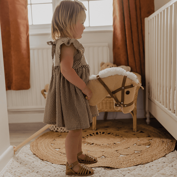 Toddler playing with the Bigjigs Cord Wooden Hobby Horse at home
