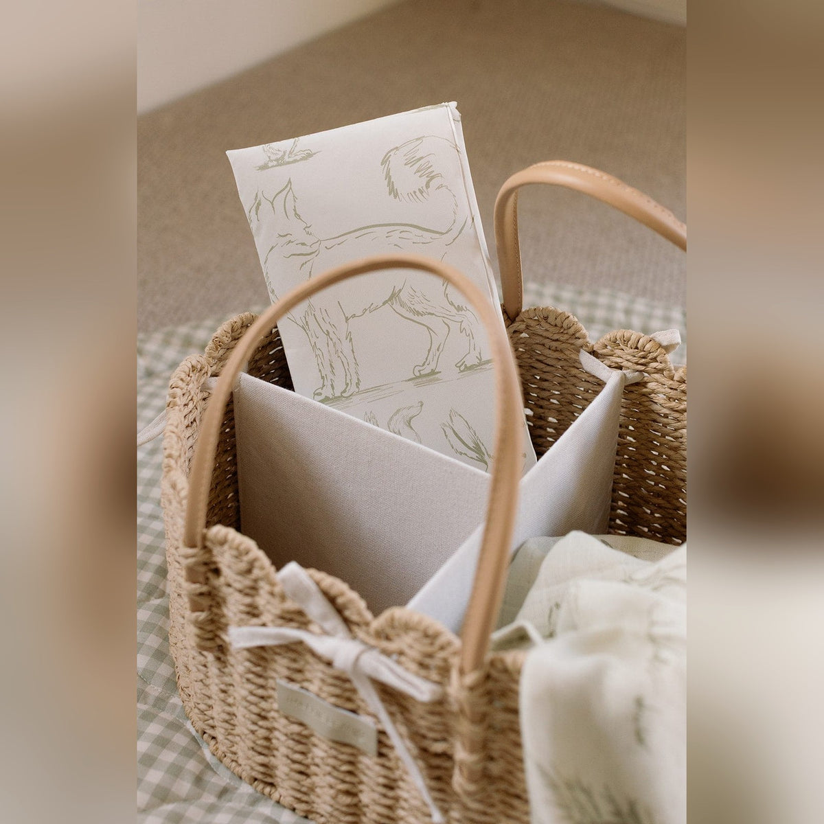 Close up of the scallop edge nappy caddy's woven trim, handles and bow